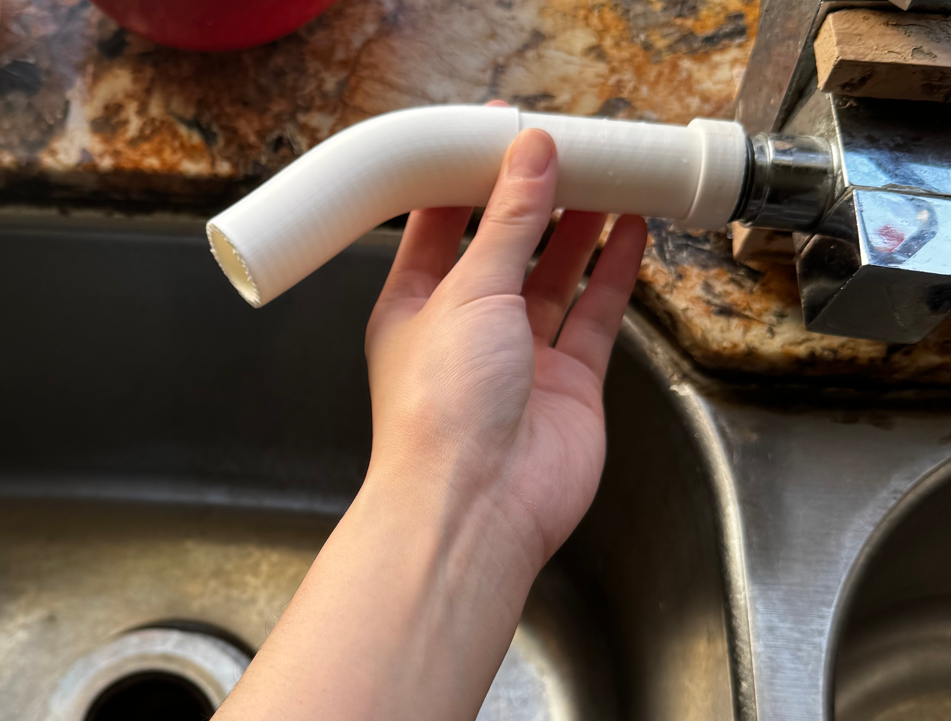 3D printed pipe connected to a sink hose.